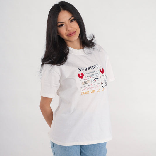 90s Nurse Graphic T-Shirt "Care We Do Best" Embroidered White Cotton Medium M